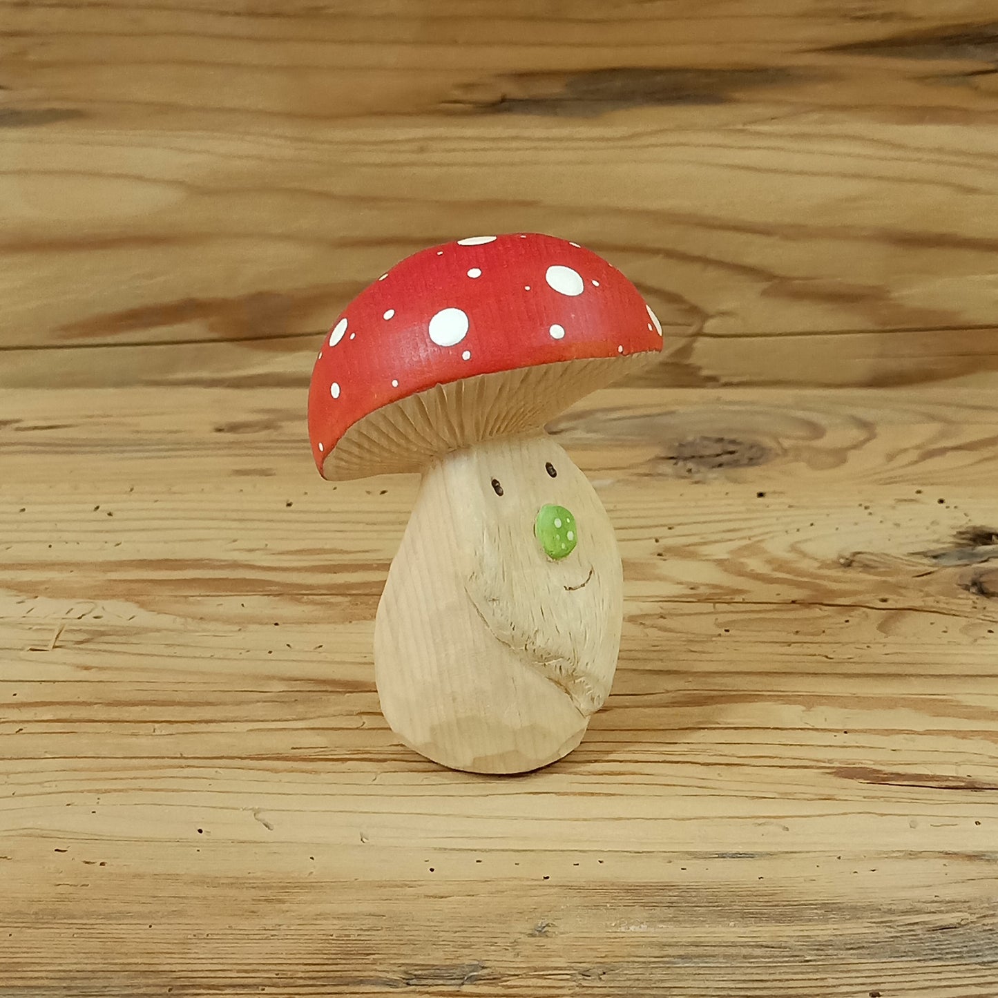 Handgeschnitzter Glückszwerg aus Zirbenholz mit Fliegenpilzhut, gefertigt von David, dem Zauberschnitzer aus Südtirol.