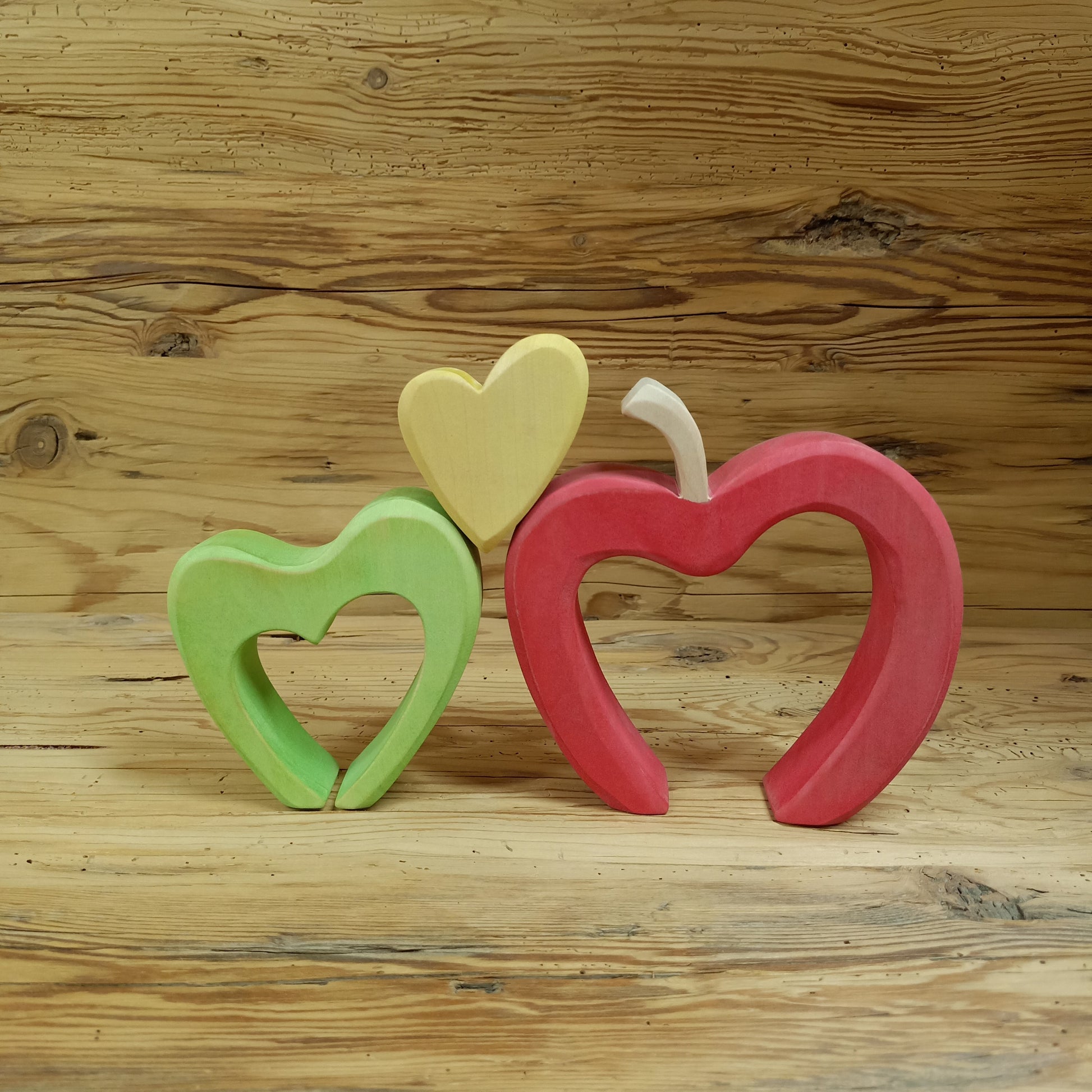 Handgefertigter Südtiroler Herzapfel aus Holz von NaturWunderWerk – zauberhaftes Herzstapelspiel in den Farben der Südtiroler Apfelsorten Royal Gala, Granny Smith und Golden Delicious für Kinder und Erwachsene.