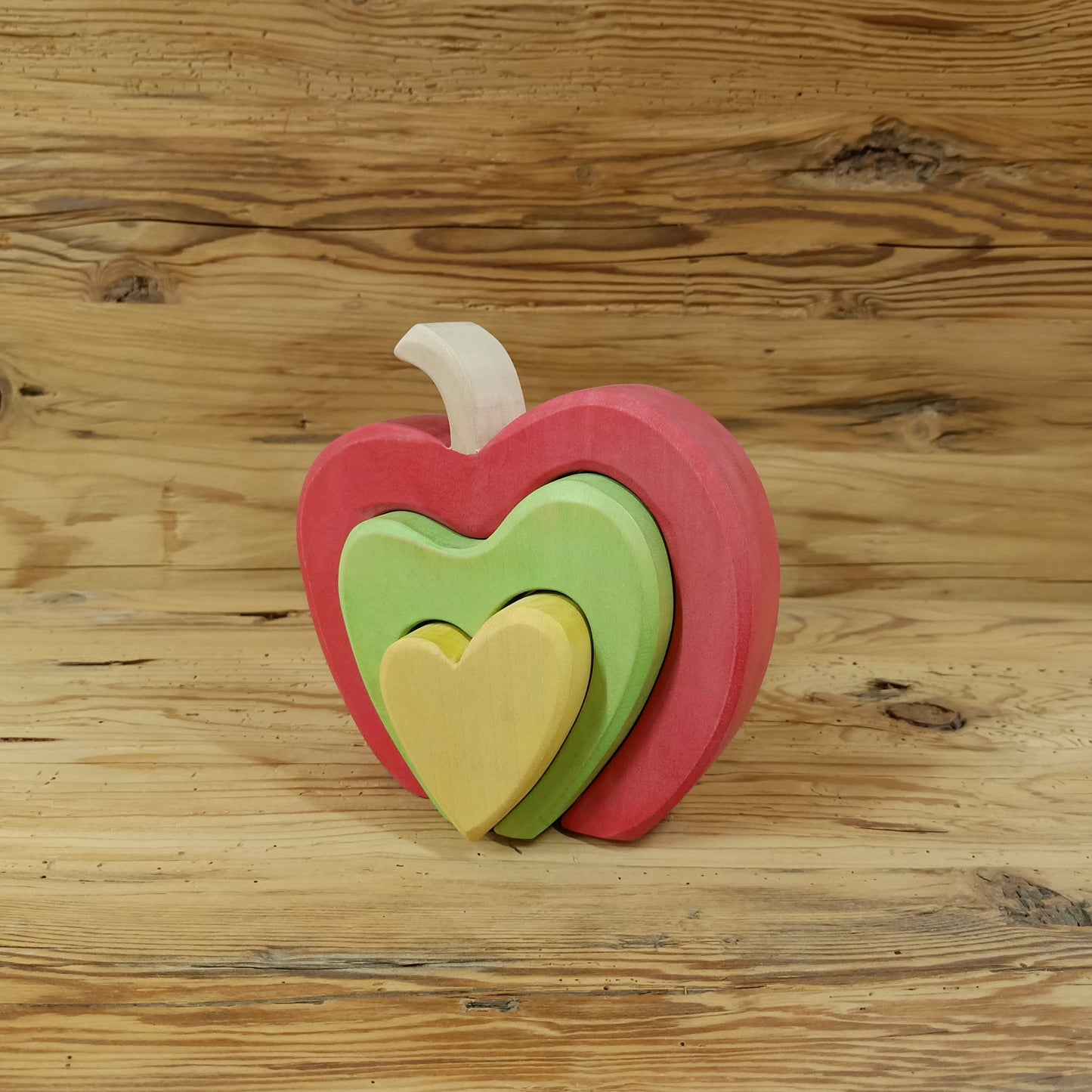 Handgefertigter Südtiroler Herzapfel aus Holz von NaturWunderWerk – zauberhaftes Herzstapelspiel in den Farben der Südtiroler Apfelsorten Royal Gala, Granny Smith und Golden Delicious für Kinder und Erwachsene.